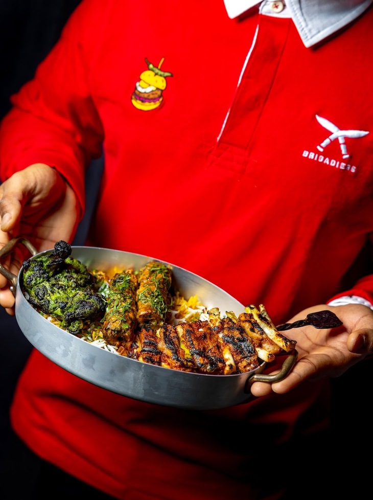 A person in a Welsh jersey holding Indian cuisine