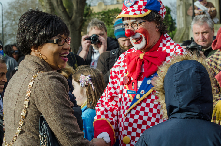 A clown chatting to people