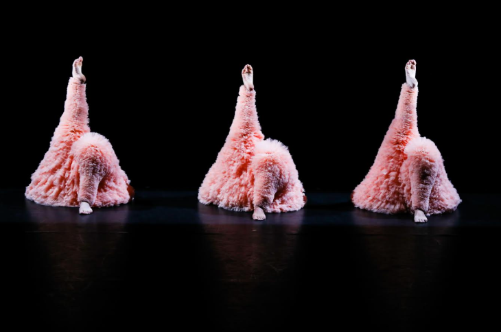 Top events in London today:  three dancers laying on the floor in fluffy pink costumes, each with their right leg pointing up in the air