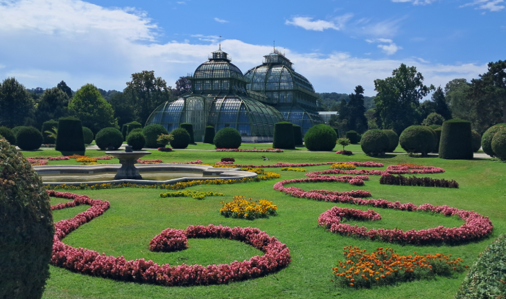 Best things to do in Vienna: colourful flowerbeds in front of a glass house