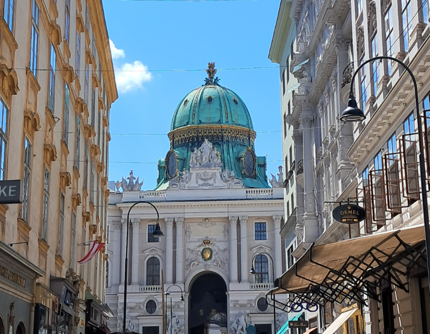 Best things to do in Vienna: Looking down a Viennese street towards a building topped with a green dome 