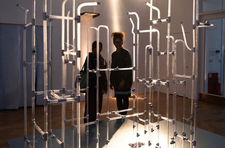 People looking at an exhibit consisting of pipes