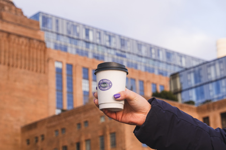 Free events in London: a takeaway cup being held up outside Battersea Power Station