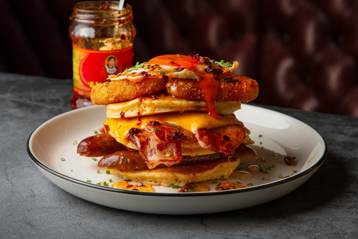 Pancake Day London 2026: a stack of savoury pancakes topped with bacon, cheese, and herbs