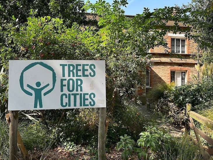 A cottage designed by Prince Albert with a trees for cities sign in front