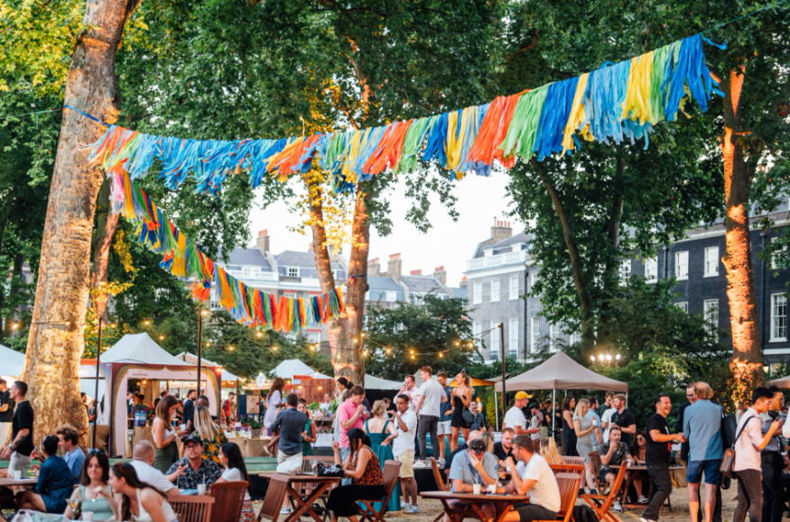 What's on in London Summer 2026: people eating and drinking at an open-air festival, beneath colourful bunting