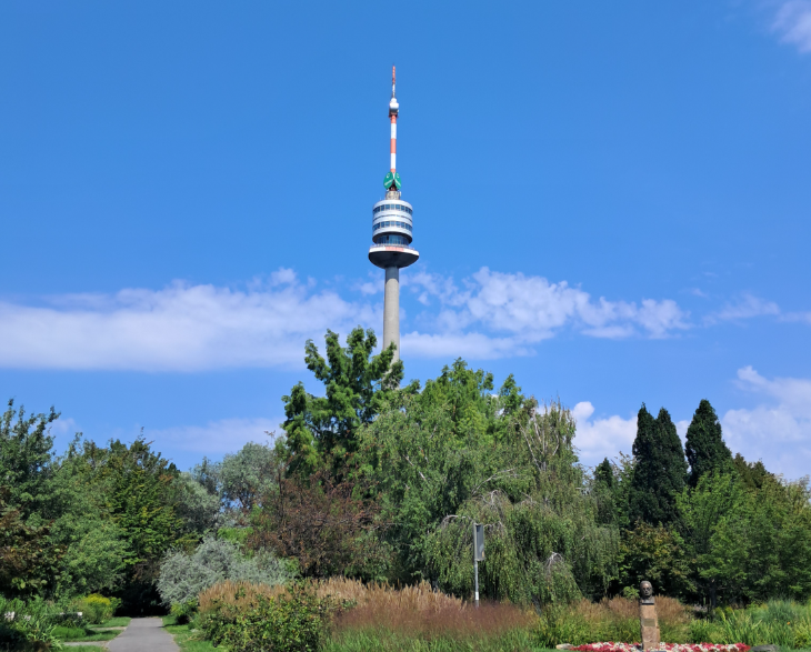 Best things to do in Vienna: a mast-like tower sticking up beyond some trees