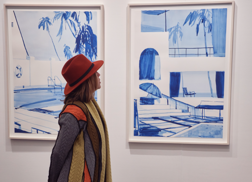 Things to do in London this weekend: a woman admiring two blue and white paintings on a gallery wall