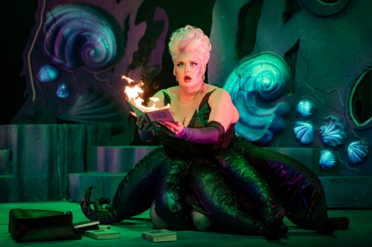 Best events in London in February 2026: an actor dressed as Ursula on stage, holding a flaming book