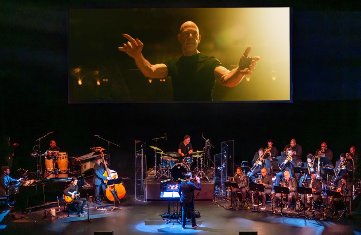 Things to do in London today: an orchestra playing on stage, with a film showing on a large screen behind them