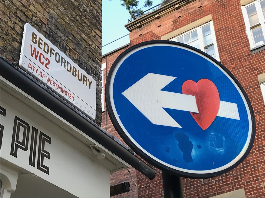 An arrow through a heart on a street sign