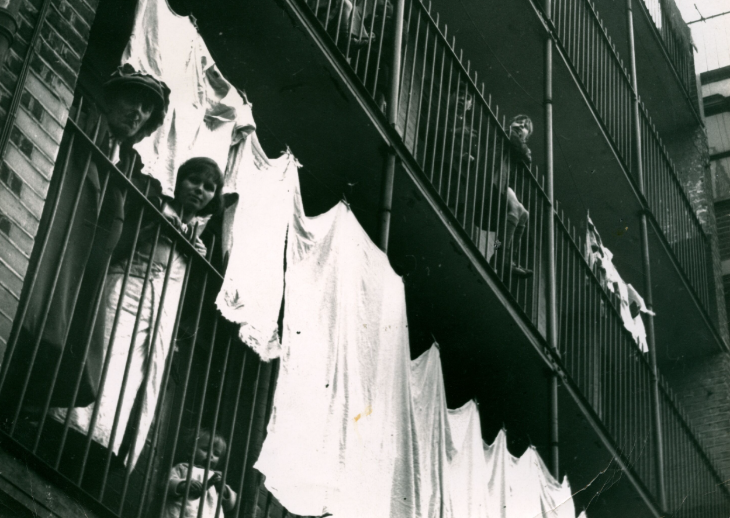 What's on in London today:  a black and white photograph of people and laundry on balconies