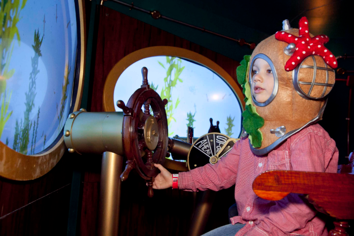 Top events in London today: a child in fancy dress operating a fake ship's wheel