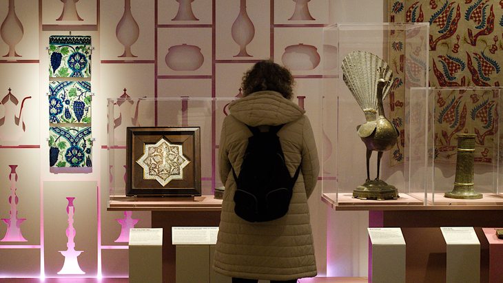 Free museums: A person studying an exhibition on Islamic art 