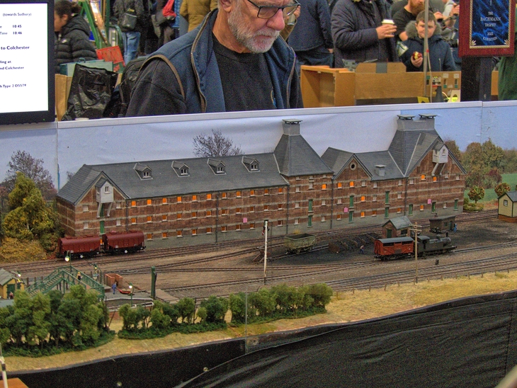 a man looking over a model railway setup