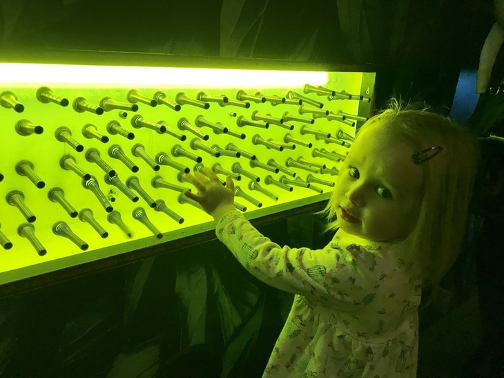 Free London museums: a young girl playing with an interactive exhibit glowing green