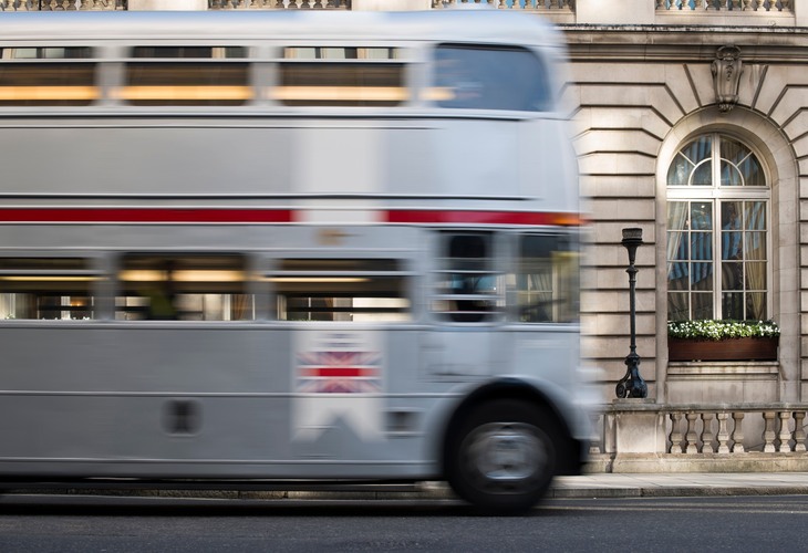 A Silver Routemaster running past a hotel