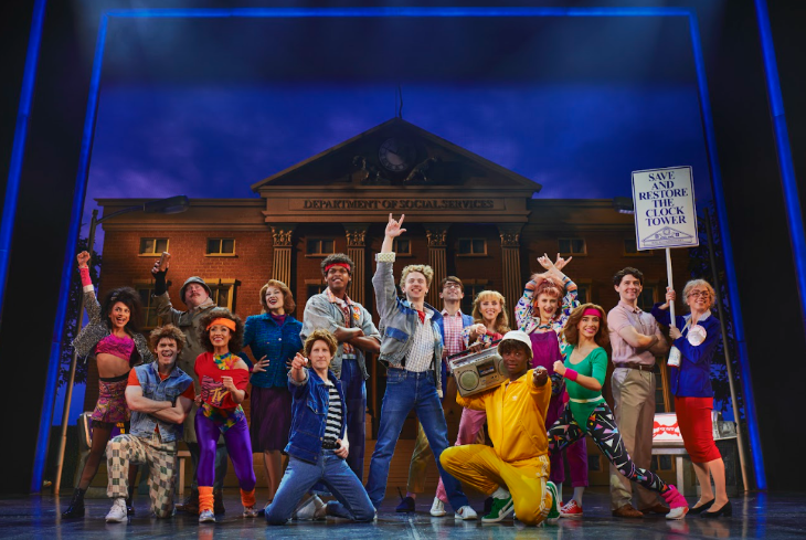 Family-friendly theatre shows London: the cast of Back to the Future posing in front of the Town Hall facade set