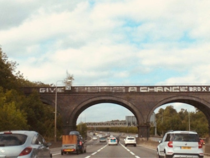 A motorway bridge saying Give Peas a Chance