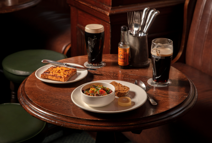 St Patrick's day in London 2026: a pub table with two pints of Guinness and some plates of food