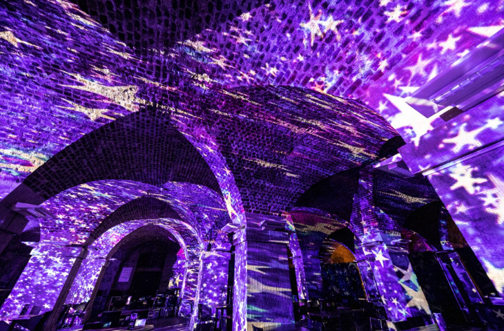 Best events in London today: the brick interior of a church crypt illuminated with purple and white starry projections