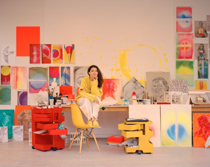 Autumn 2026 events London: Es Devlin sitting on a desk, surrounded by her works