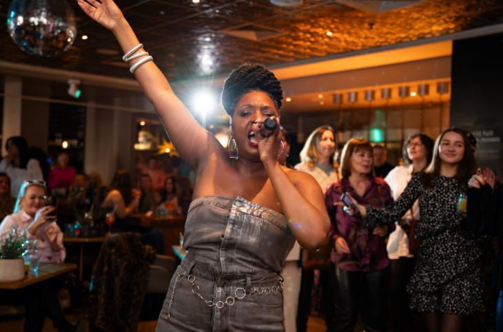 Top events in London this weekend: a singer holding a microphone, with the other hand up in the air