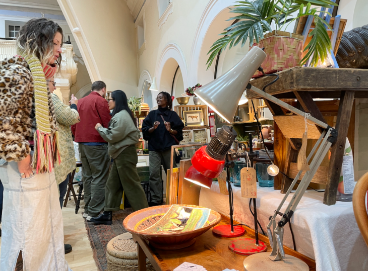 Top things to do in London today: a woman looking at objects at a vintage fair