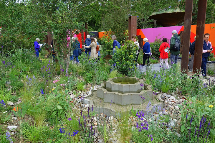 London flower festivals: people walking through a show garden at the Chelsea Flower Show