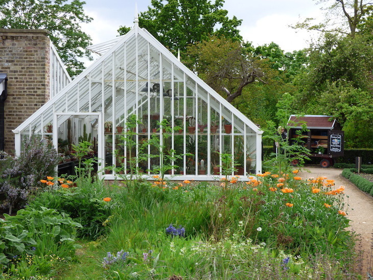 Best London gardens to visit: a greenhouse surrounded by plants at Myddelton House Gardens