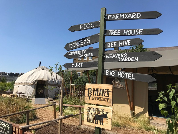 Animal days out in London:  a signpost in a farmyard pointing to things including pigs, donkeys, yurt and beehives