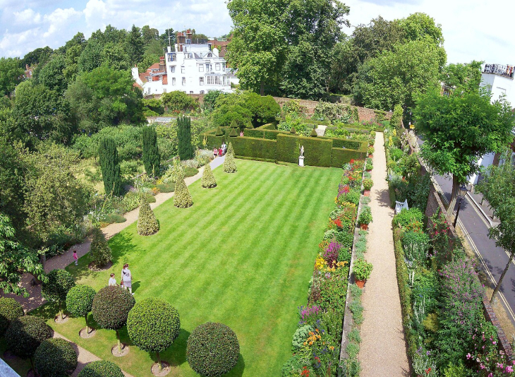 Best London gardens to visit: looking down onto a tidy rectangular lawn surrounded by colourful flowers