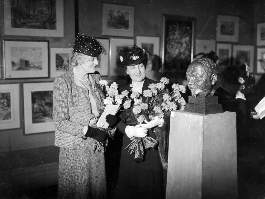 Women holding flowers at an exhibition