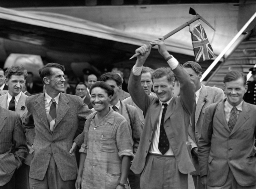 People coming off a flight with a British flag on a pick axe