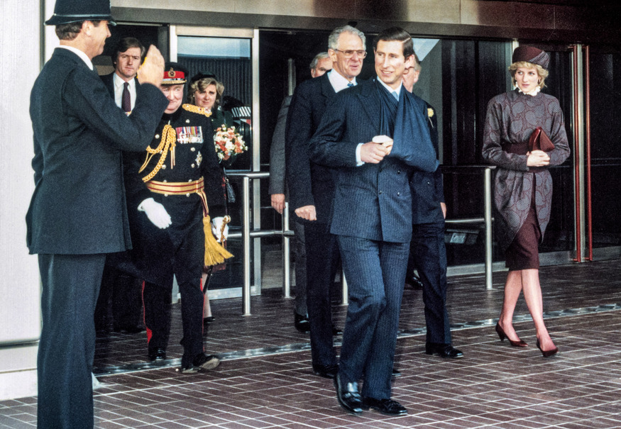 Then Prince Charles leaving the airport in a sling