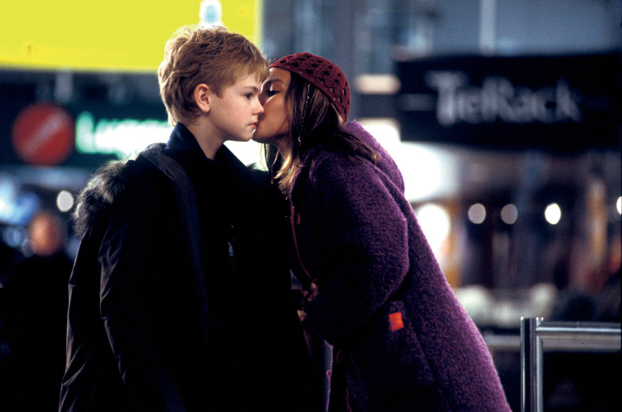 A girl kisses a boy on the cheek