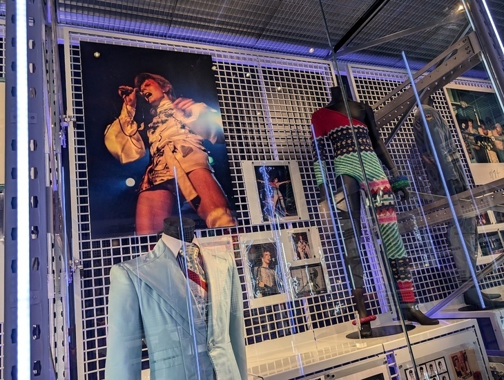 Best things to do in outer London: a display of David Bowie costumes and photos in a glass case at a museum
