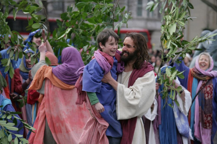 Easter weekend events in London: a performer in the role of Jesus carrying a boy through Trafalgar Square