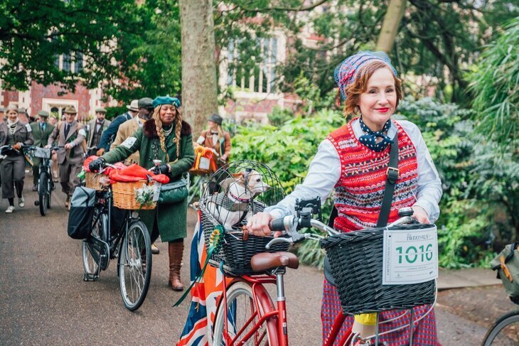 What's on in London in April 2026: a woman pushing her bike with a small dog in a cage on the back