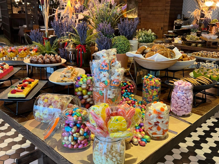Easter weekend events in London: a buffet laid out on a table including Easter eggs, sweets and hot cross buns
