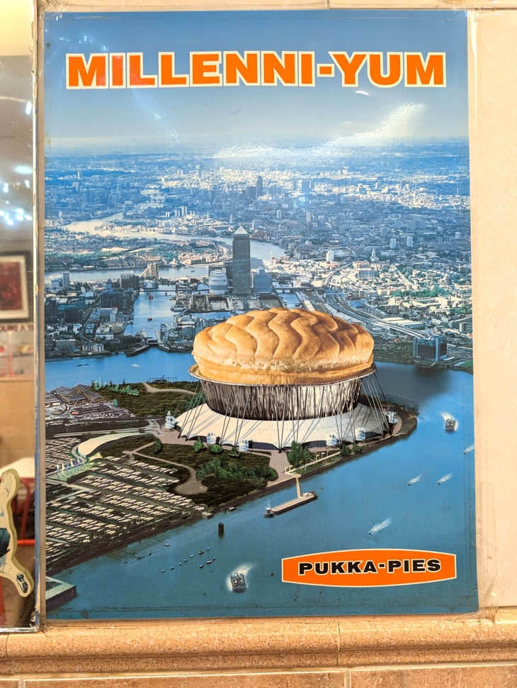 A Pukka Pies posters with the Millennium Dome as a pie