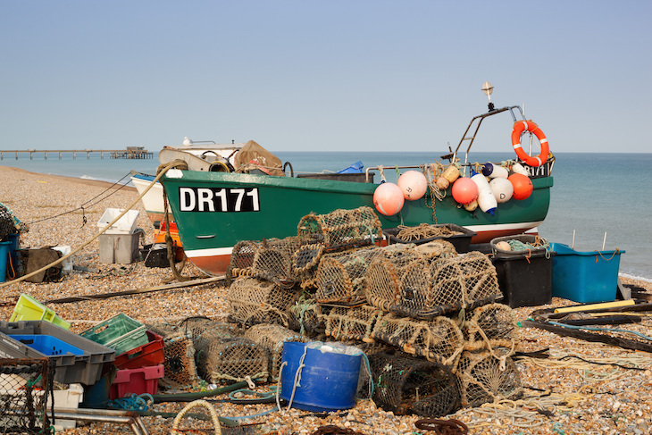 Ken seaside towns for a day trip: A fishing boat on the beach between Walmer and Deal - you can see Deal Pier in the background.