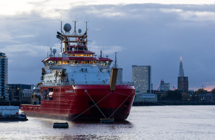 David Attenborough's London: The RRS Sir David Attenborough, a large red and white polar research ship, is moored on a river in London at dusk with the city skyline and The Shard in the background.