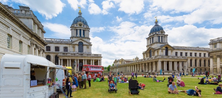 Things to do in London in half term May 2026: people sitting on the lawns in front of the Old Royal Naval College in the sunshine