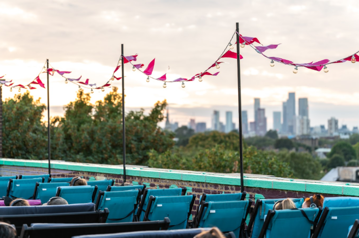 Things to do in London in May half term: seats at an open-air rooftop cinema, with bunting fluttering above, and the London skyline in the distance