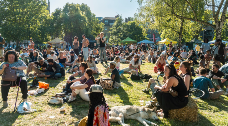 Top things to do in London in May 2026: crowds of people sitting on the grass in park in the sunshine