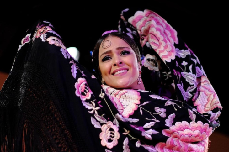 Things to do in London this bank holiday weekend: a flamenco dancer, arms in the air, in a black and pink floral costume