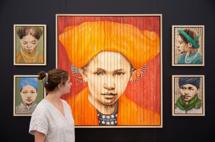 Top events in London today: a woman admiring a large artwork of a person in orange coat and hat, surrounded by four smaller portriats