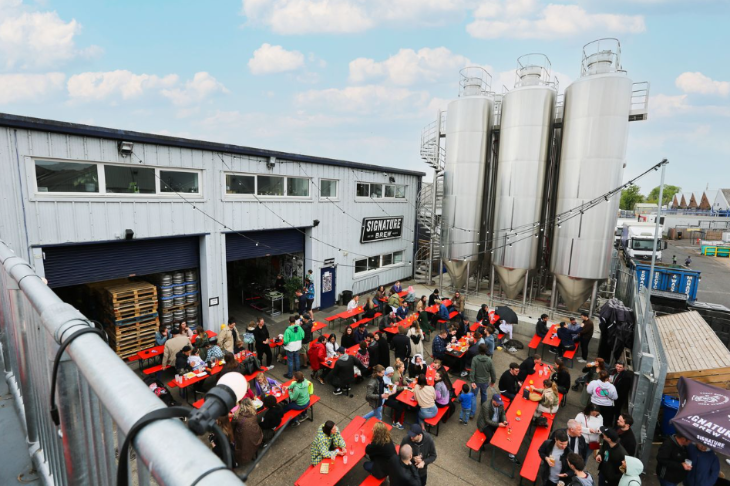 Things to do in London today:  people sitting in an open-air courtyard at a brewery
