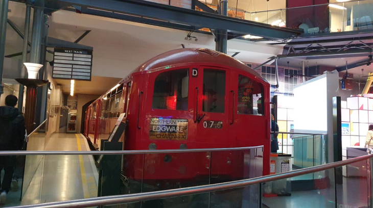 Things to do in London today: A vintage red London Underground train car on display inside the London Transport Museum, featuring a destination sign for Edgware via Charing Cross.